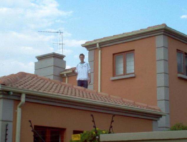 Craig on roof of garage standing on the confluence spot